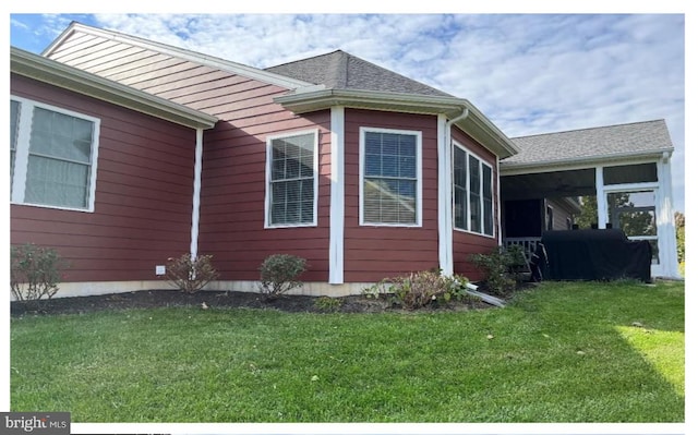 view of side of home featuring a yard and a sunroom