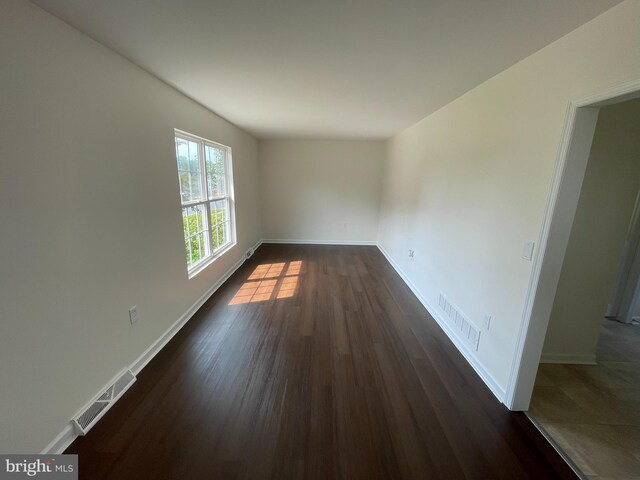 unfurnished room featuring dark wood-type flooring