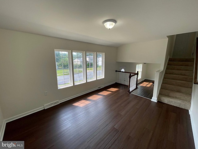 unfurnished living room with dark hardwood / wood-style floors