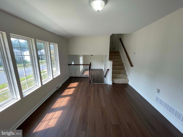 unfurnished living room with dark hardwood / wood-style flooring