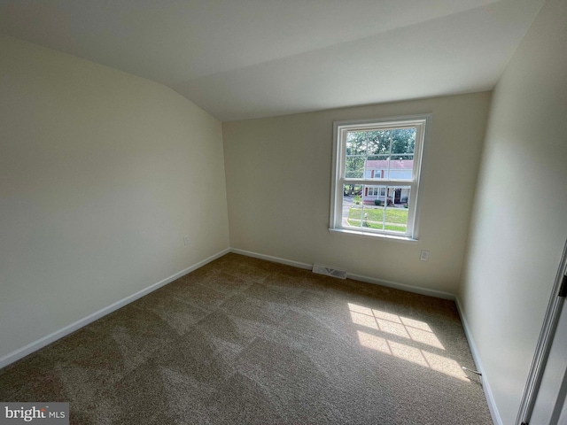 unfurnished room with carpet floors and vaulted ceiling