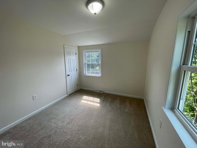 carpeted spare room featuring lofted ceiling