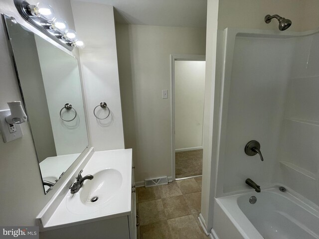 bathroom featuring tile patterned flooring, bathing tub / shower combination, and vanity