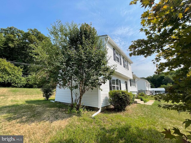 view of side of home with a yard