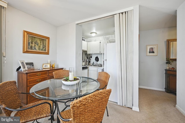 dining room with light carpet and baseboards