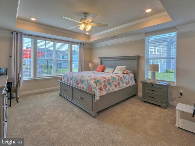 carpeted bedroom featuring ceiling fan, a raised ceiling, and ornamental molding