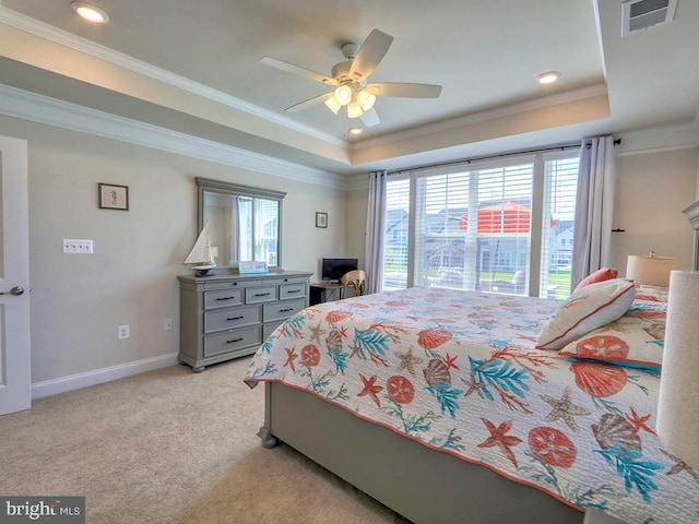 bedroom featuring baseboards, visible vents, light colored carpet, a tray ceiling, and crown molding