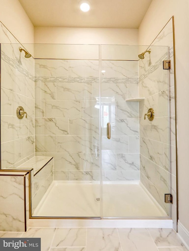 full bath featuring marble finish floor and a stall shower