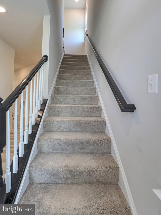 stairs with baseboards and recessed lighting