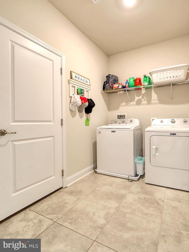 laundry room with washing machine and dryer and light tile patterned flooring