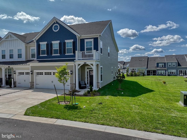 view of front of property featuring a balcony, a garage, and a front yard