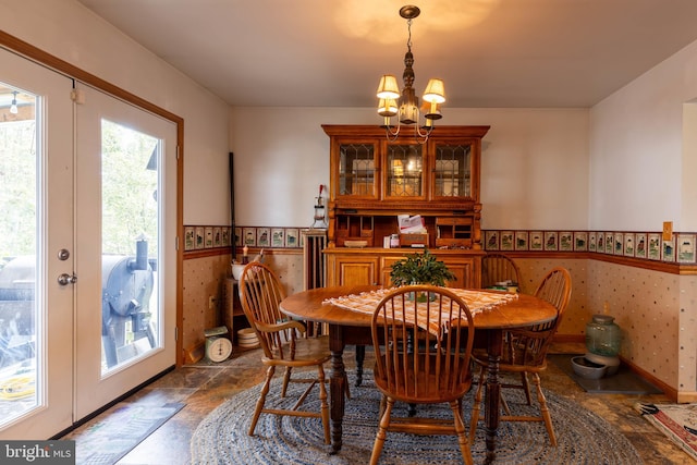 dining space with tile patterned flooring, an inviting chandelier, and french doors