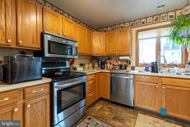 kitchen featuring appliances with stainless steel finishes, dark tile patterned floors, sink, and decorative backsplash