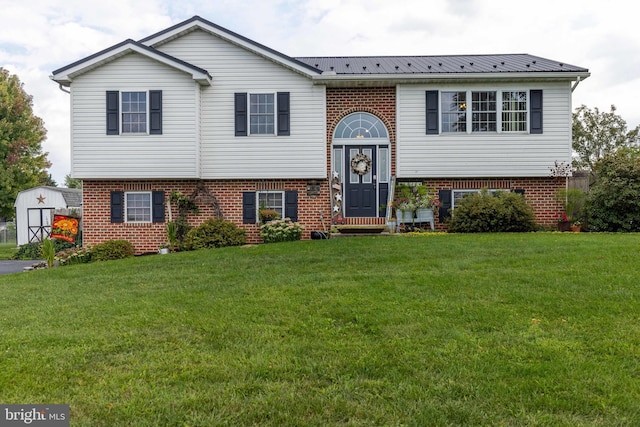 bi-level home with brick siding, metal roof, and a front lawn