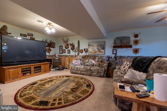 living room featuring ceiling fan, visible vents, carpet flooring, and ornamental molding