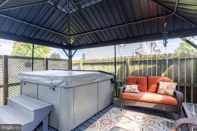 view of patio featuring a hot tub, a deck, and a gazebo