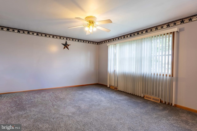 carpeted empty room with visible vents, ceiling fan, and baseboards