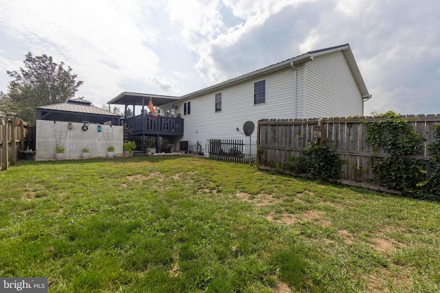 rear view of property with a yard, a fenced backyard, and a gazebo