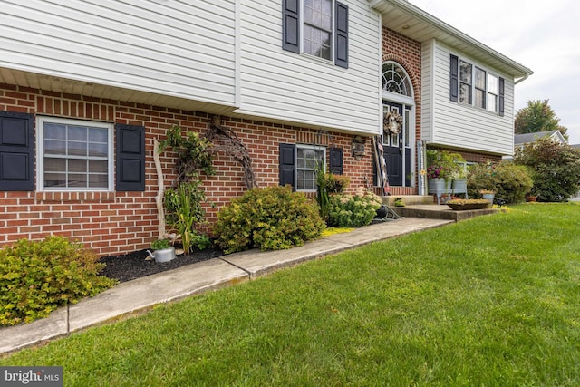 view of front of home featuring a front lawn and brick siding