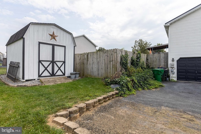 view of shed with fence and driveway