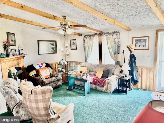 living room featuring beamed ceiling, a textured ceiling, carpet floors, and ceiling fan