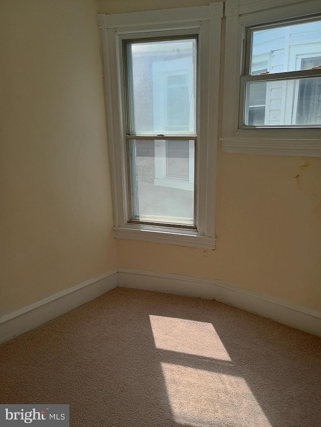 carpeted spare room with a healthy amount of sunlight