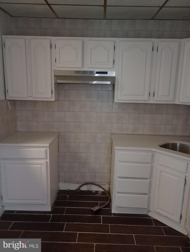 kitchen with white cabinets, sink, and a drop ceiling