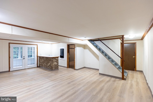 basement with light hardwood / wood-style flooring, french doors, and crown molding