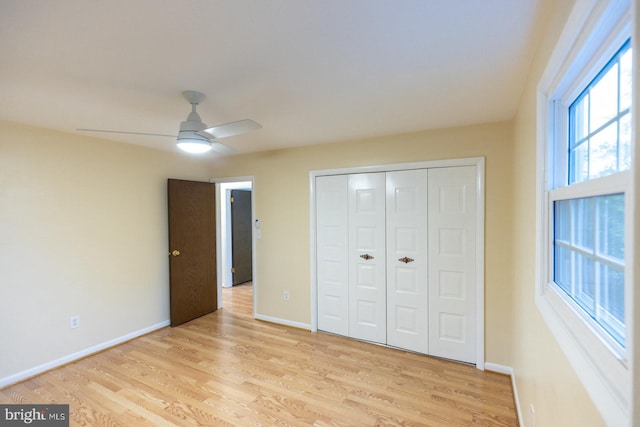 unfurnished bedroom featuring a closet, light hardwood / wood-style floors, and ceiling fan