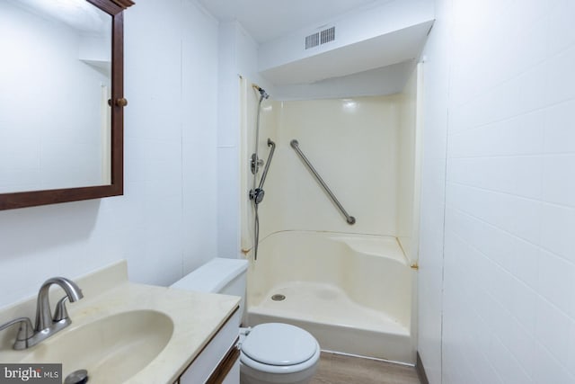 bathroom featuring vanity, a shower, toilet, and wood-type flooring