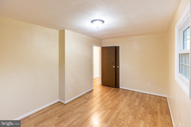 empty room featuring light hardwood / wood-style flooring and a textured ceiling