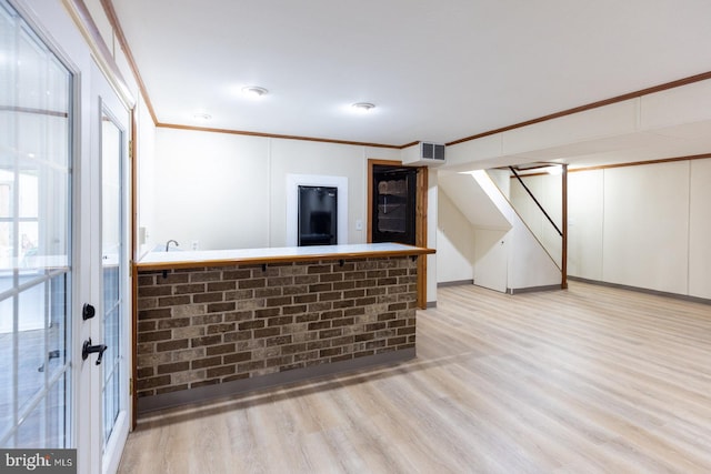 interior space featuring light hardwood / wood-style flooring, bar, and crown molding