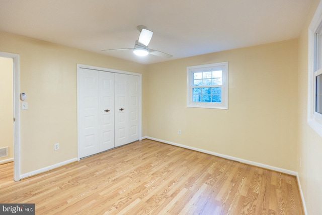 unfurnished bedroom with a closet, light hardwood / wood-style floors, and ceiling fan