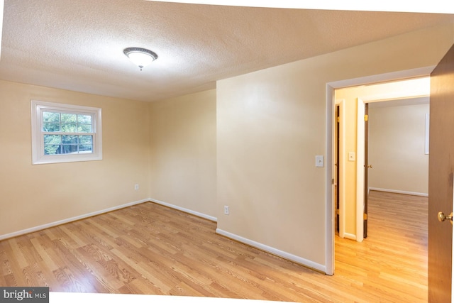 empty room featuring light hardwood / wood-style floors and a textured ceiling