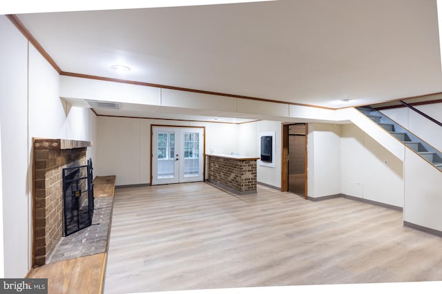 unfurnished living room with light wood-type flooring, crown molding, and a fireplace