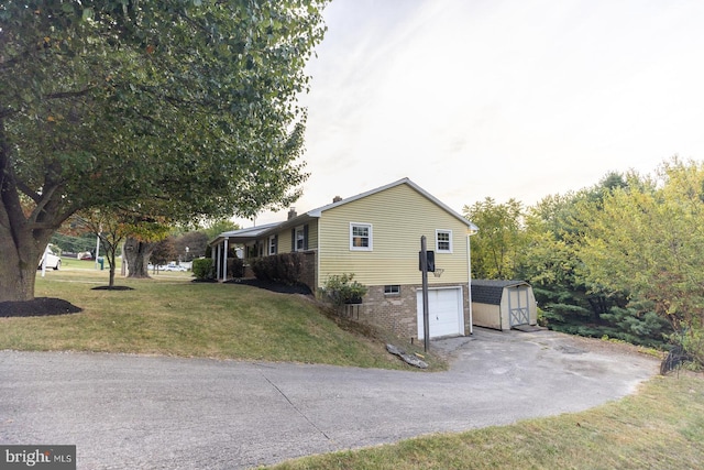 view of side of property featuring a yard, an outdoor structure, and a garage