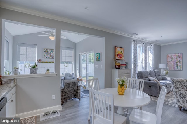 dining area with ceiling fan, light wood-type flooring, and vaulted ceiling