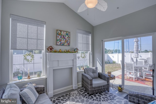 sitting room with a wealth of natural light, a fireplace, vaulted ceiling, and ceiling fan