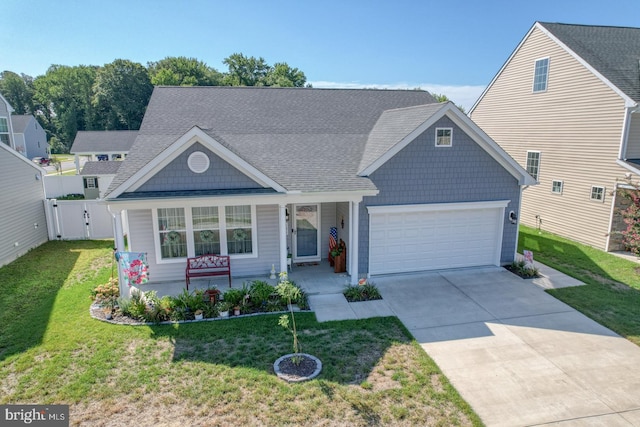 view of front of home featuring a porch, an attached garage, driveway, roof with shingles, and a front yard