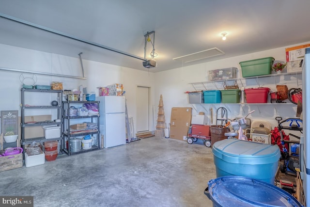 garage featuring freestanding refrigerator and a garage door opener