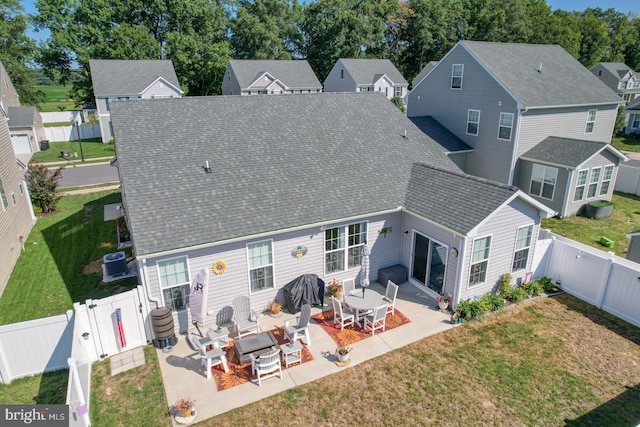 back of house with roof with shingles, a patio area, cooling unit, a fenced backyard, and a residential view