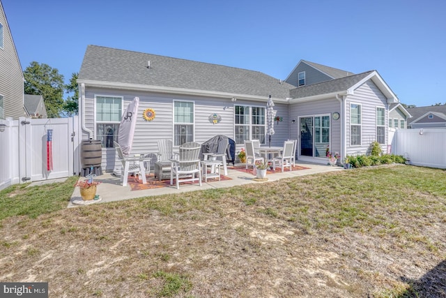 back of house with a patio and a lawn