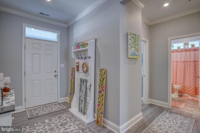 entryway featuring baseboards, plenty of natural light, wood finished floors, and crown molding