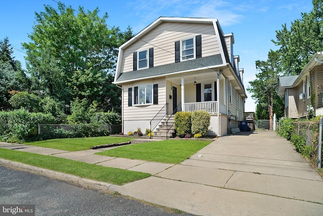 view of front of property featuring cooling unit, a porch, and a front yard