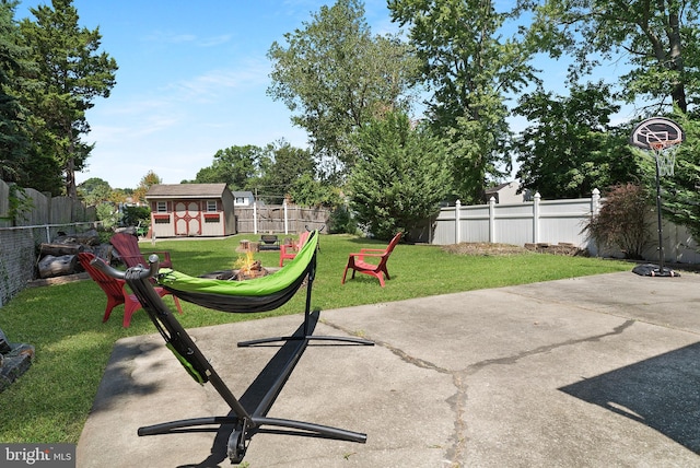 exterior space featuring a patio area, a fenced backyard, a storage unit, and an outbuilding