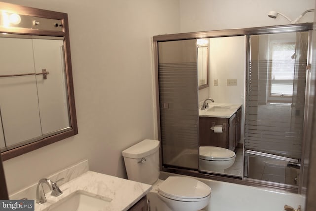 full bathroom featuring enclosed tub / shower combo, vanity, and toilet