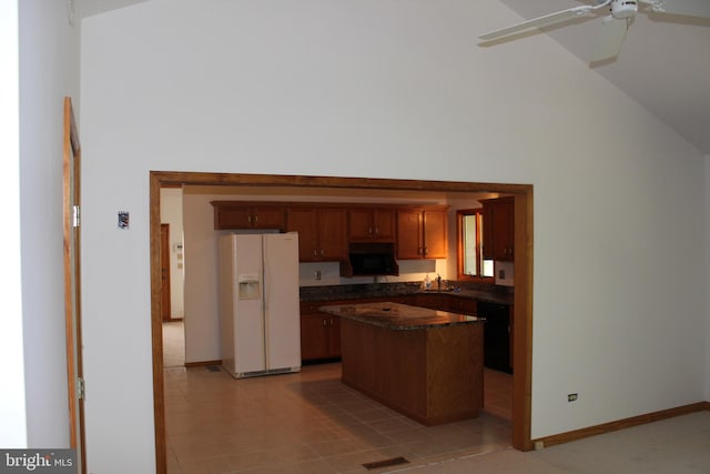 kitchen featuring ceiling fan, a center island, white fridge with ice dispenser, and light tile patterned floors