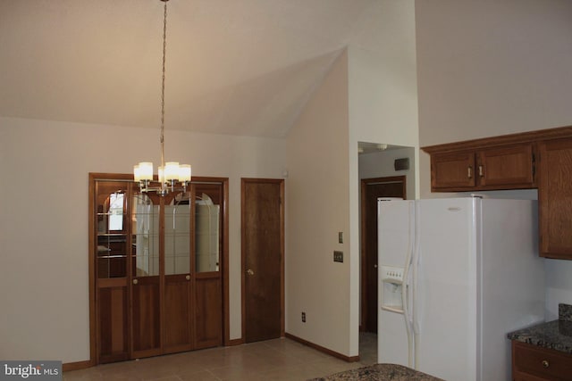 unfurnished dining area with vaulted ceiling, an inviting chandelier, and light tile patterned floors