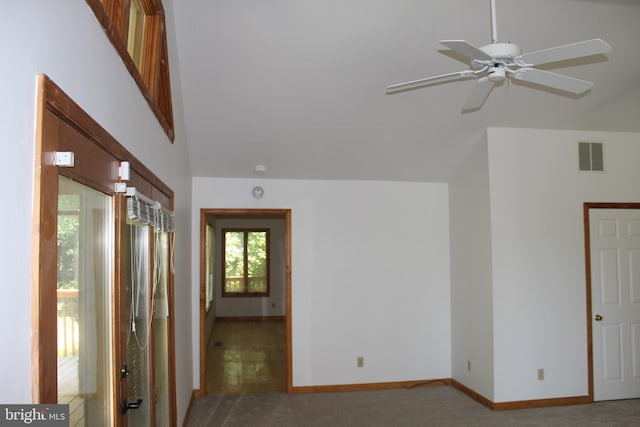 carpeted spare room featuring ceiling fan and a high ceiling