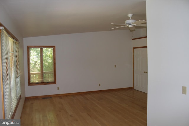 empty room featuring ceiling fan, vaulted ceiling, and light wood-type flooring